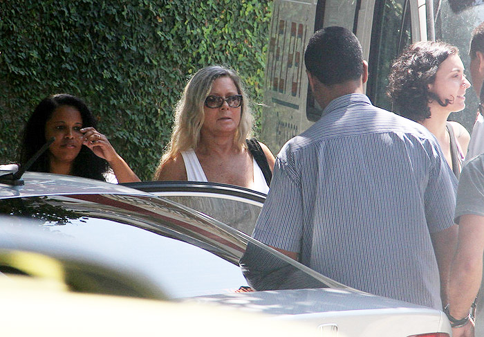 Atriz saiu do local com um vestido branco e óculos de sol. 