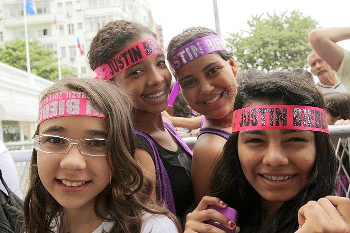 As meninas usam bandanas com o nome do ídolo teen