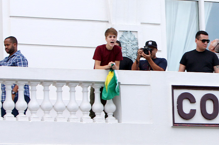 Justin Bieber aparece na sacada de hotel com bandeira do Brasil