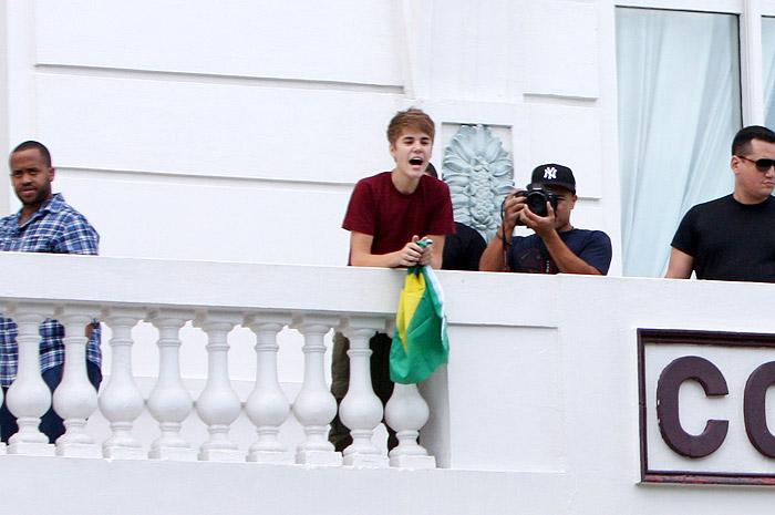 Justin Bieber aparece na sacada de hotel com bandeira do Brasil