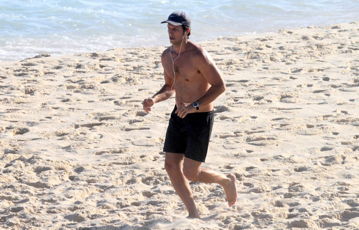 Vladimir Brichta corre sem camisa em praia carioca