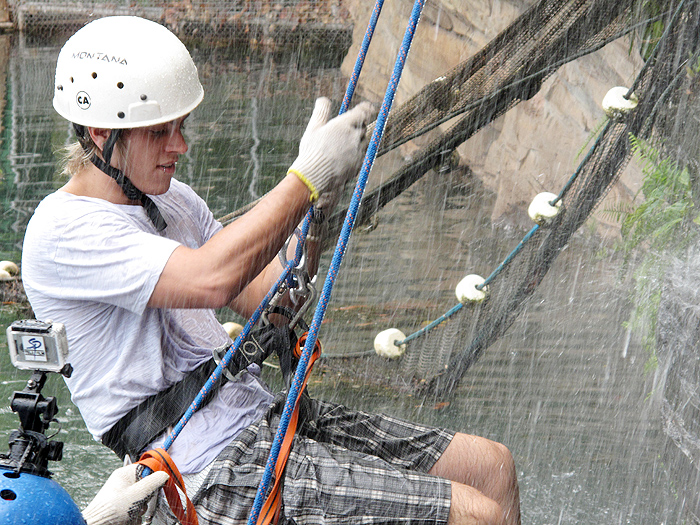 Thomas concentrado no equipamento de rapel na descida da cachoeira