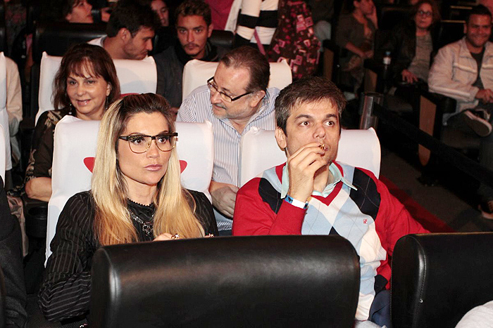 Flávia Alessandra e Otaviano Costa observam atentamente ao filme