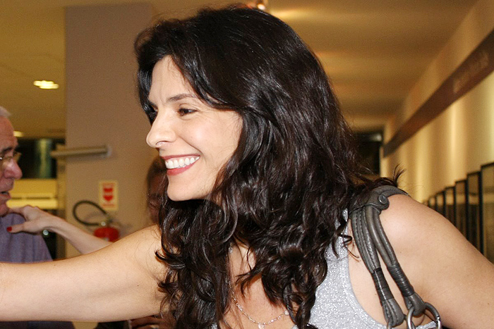 Maitê Proença aparece acompanhada em pré-estreia de filme.