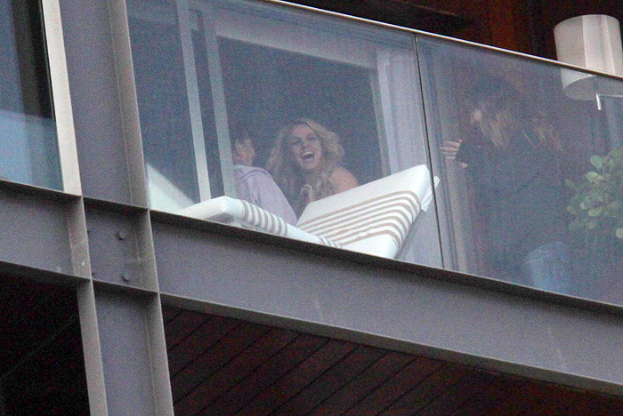 Britney Spears aparece sorridente na sacada do hotel.