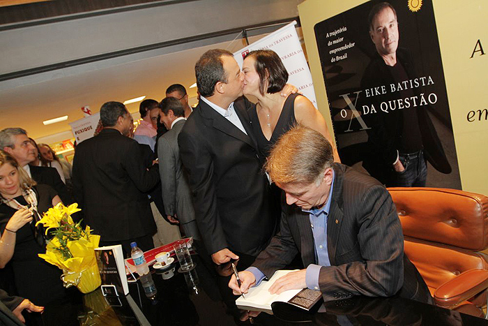 Sergio Cabral beija a mulher enquanto Eike Batista autografa o livro.