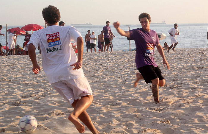 Felipe Dylon joga futebol com amigos na praia