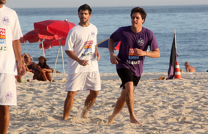 Felipe Dylon joga futebol com amigos na praia
