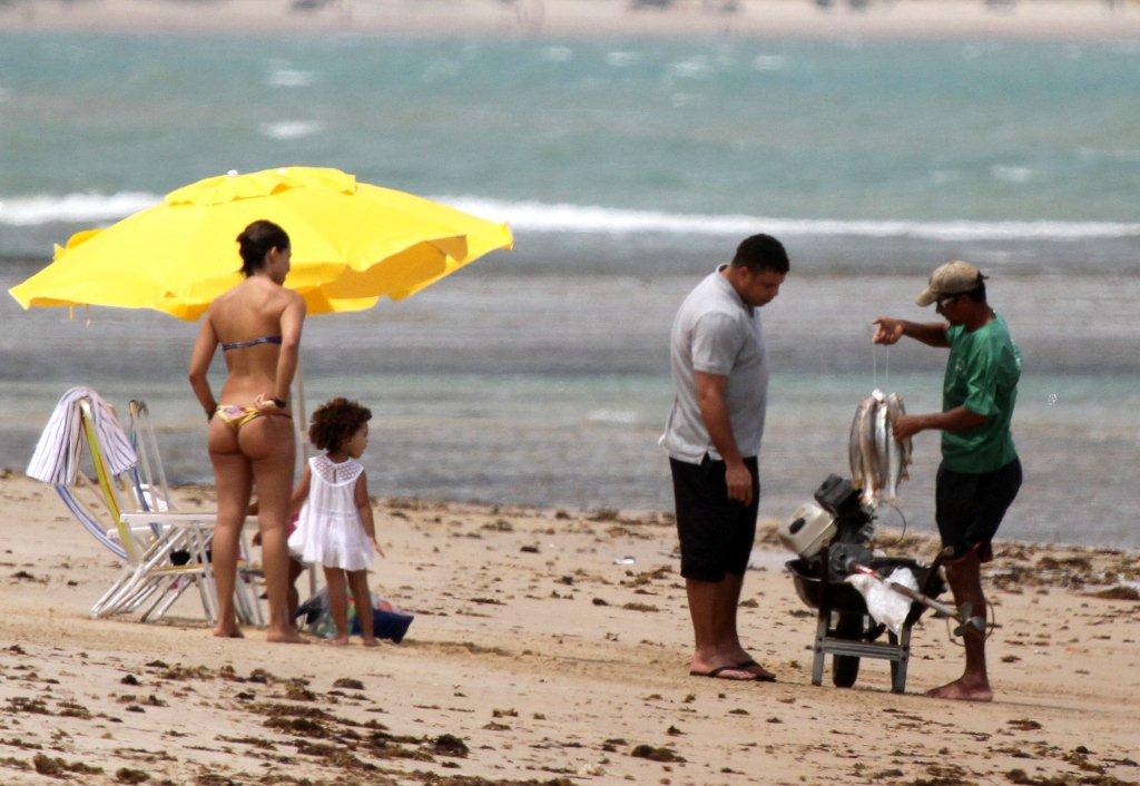 A esposa, Bia Antony e a filha mais velha observam Ronaldo negociando com um pescador nativo