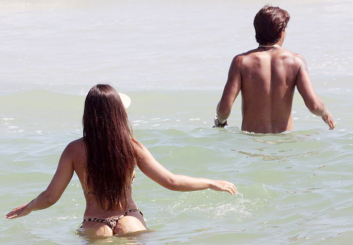 De fio dental, Nicole Bahls curte praia com o namorado no Rio de Janeiro