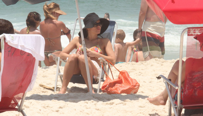 Carolina Dieckman lê biografia de Steve Jobs na praia. OFuxico