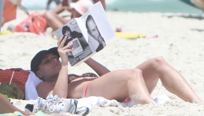 Carolina Dieckman lê biografia de Steve Jobs na praia. OFuxico