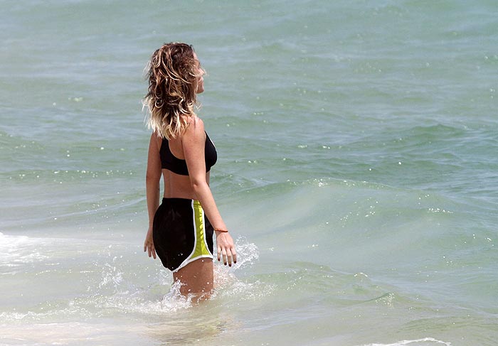 Depois de caminhada, Juliana Didone se refresca no mar