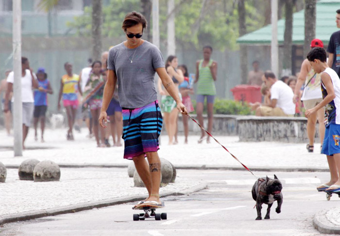 Paulinho Vilhena anda de skate com seu cachorro, no Rio