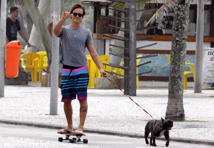 Paulinho Vilhena anda de skate com seu cachorro, no Rio