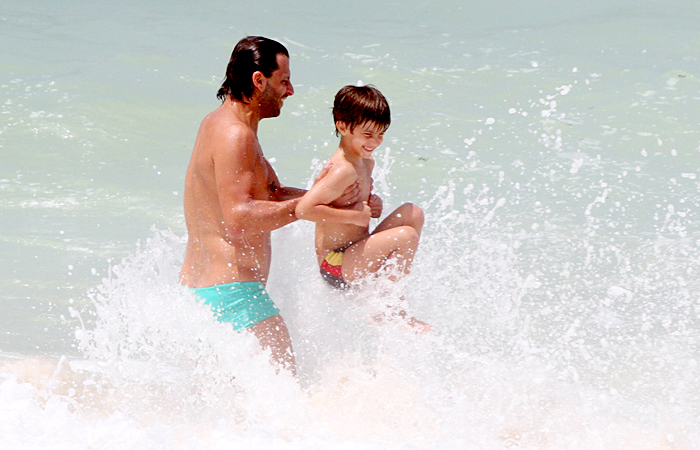 Henri Castelli se diverte com o filho na praia da Macumba, no Rio - Ag.News