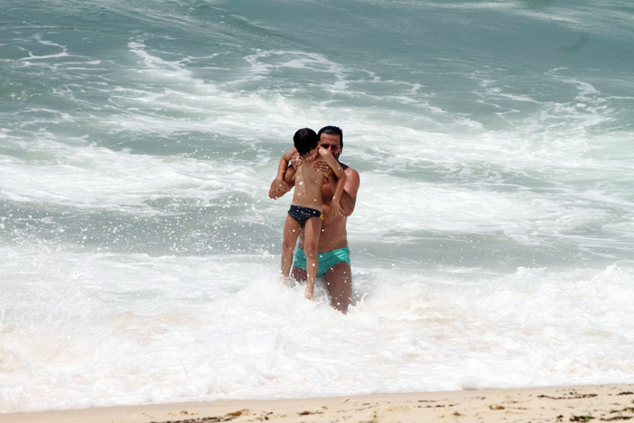 Henri Castelli se diverte com o filho na praia da Macumba, no Rio