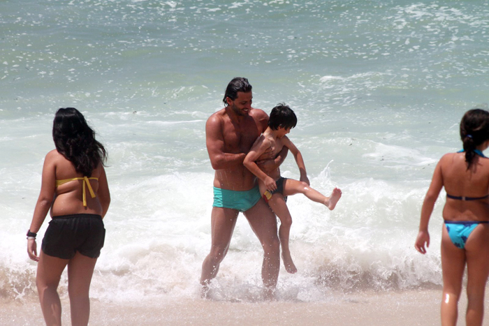 Henri Castelli se diverte com o filho na praia da Macumba, no Rio