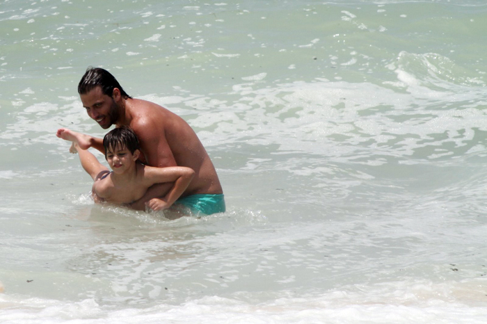 Henri Castelli se diverte com o filho na praia da Macumba, no Rio