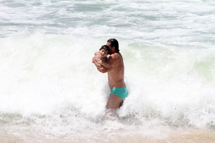 Henri Castelli se diverte com o filho na praia da Macumba, no Rio