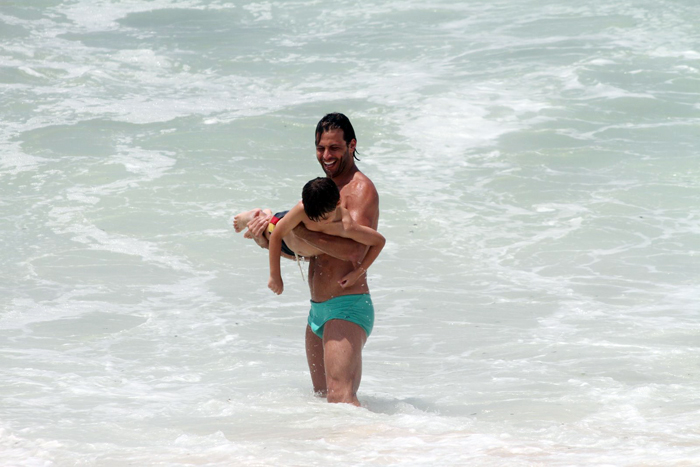 Henri Castelli se diverte com o filho na praia da Macumba, no Rio