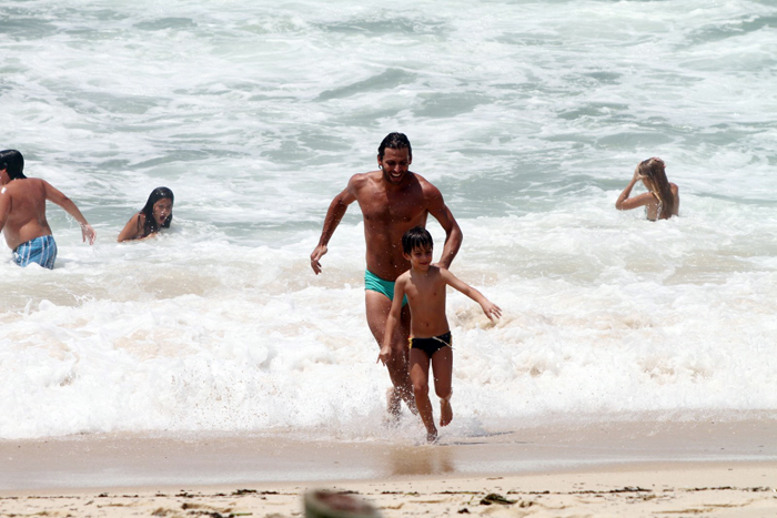 Henri Castelli se diverte com o filho na praia da Macumba, no Rio