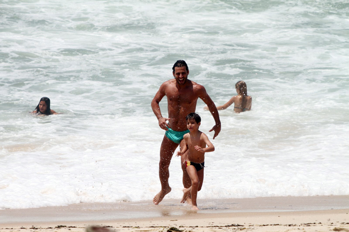 Henri Castelli se diverte com o filho na praia da Macumba, no Rio