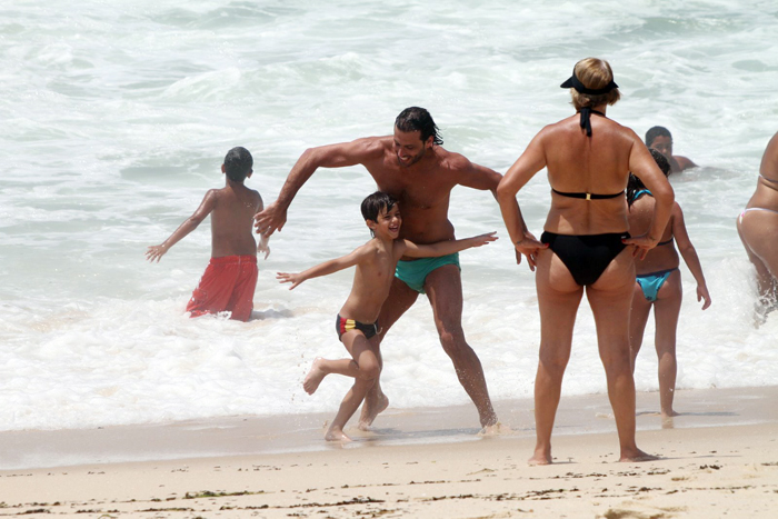 Henri Castelli se diverte com o filho na praia da Macumba, no Rio