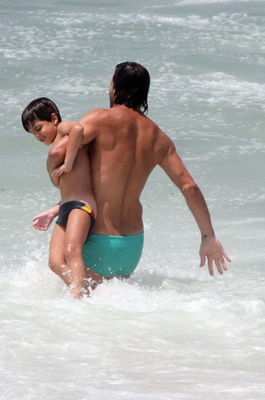 Henri Castelli se diverte com o filho na praia da Macumba, no Rio