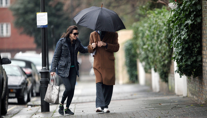 Paul McCartney e Nancy Shevell se divertem tomando chuva, em Londres.