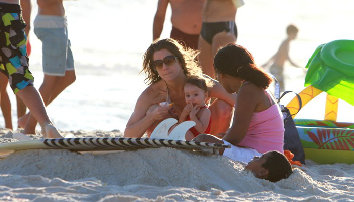 Letícia Spiller e Marcello Novaes levam os filhos à praia juntos