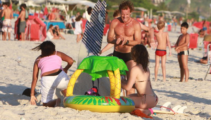 Letícia Spiller e Marcello Novaes levam os filhos à praia juntos