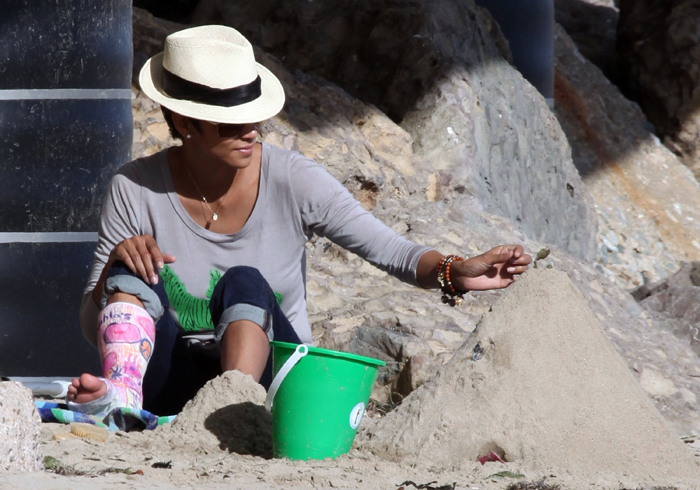 Halle Berry vai à praia com a perna engessada