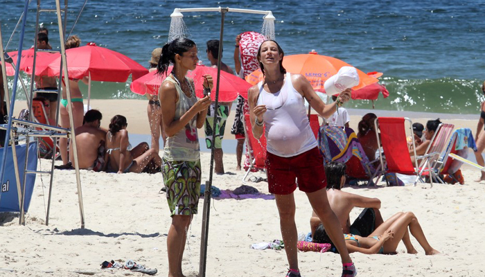 De roupa e tudo, Luana Piovani toma chuveirada na praia