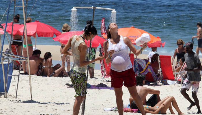 De roupa e tudo, Luana Piovani toma chuveirada na praia