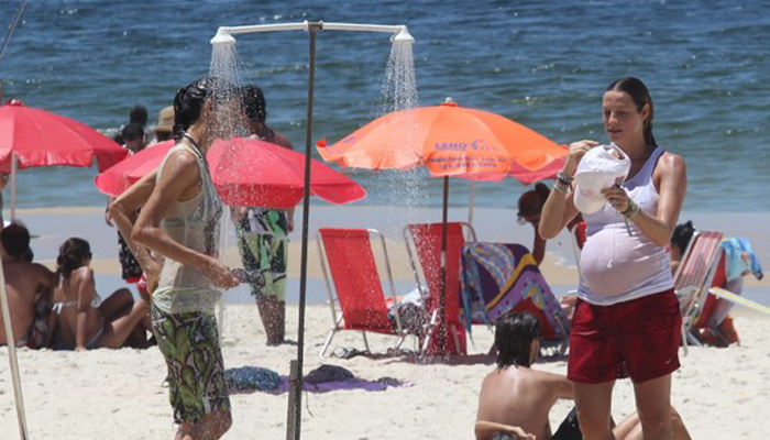 De roupa e tudo, Luana Piovani toma chuveirada na praia