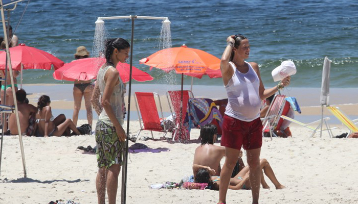 De roupa e tudo, Luana Piovani toma chuveirada na praia