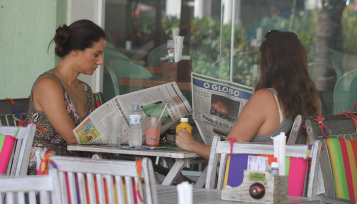 Mônica Carvalho lê jornal enquanto almoça no Rio