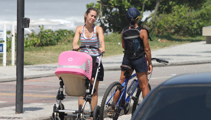 Dani Monteiro corre para atravessar a rua com a filha