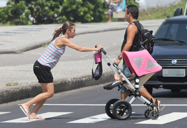 Dani Monteiro corre para atravessar a rua com a filha