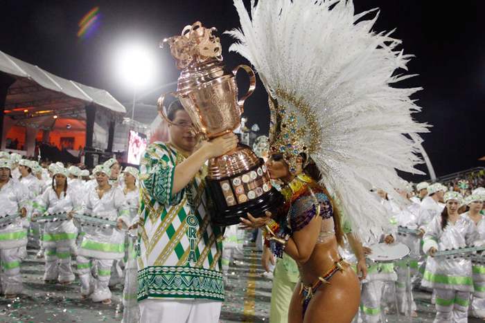 Viviane Araújo beija o troféu à frente da bateria da Mancha