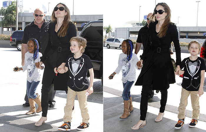 Shiloh Jolie-Pitt faz pose para fotógrafos durante embarque de aeroporto