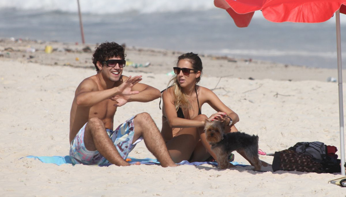 Caio Castro curte praia bem acompanhado