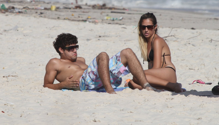 Caio Castro curte praia bem acompanhado