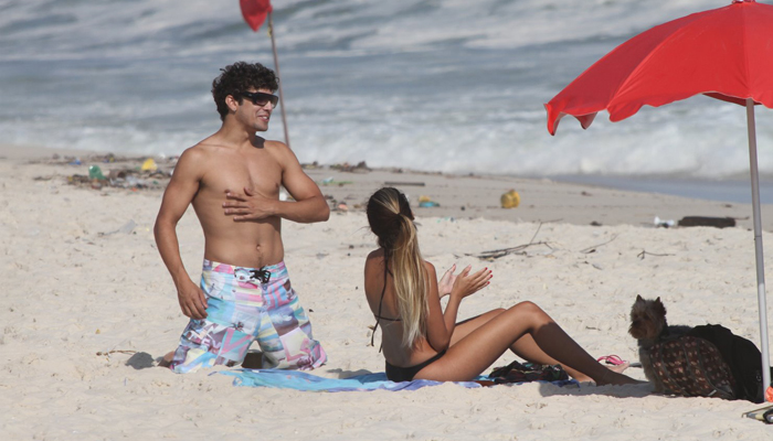 Caio Castro curte praia bem acompanhado