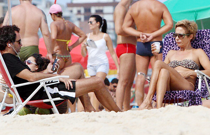 Andréa Beltrão curte praia com cervejinha ao lado do marido