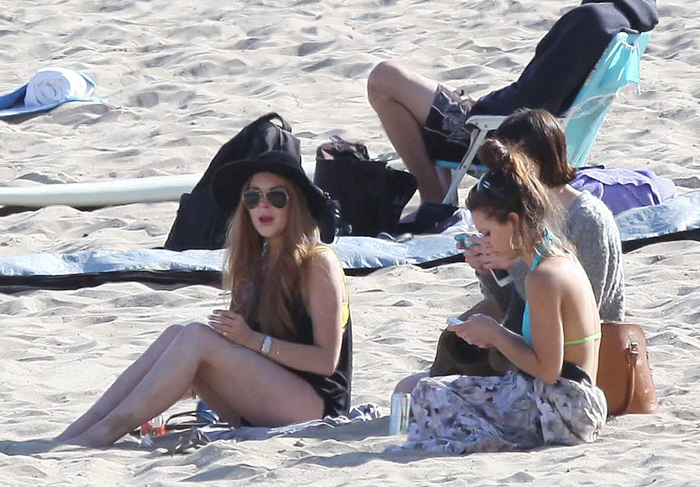 Lindsay Lohan vai à praia, mas passa frio