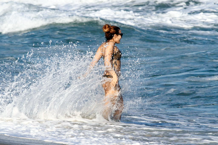 No Rio, Demi Lovato toma banho de mar e faz embaixadinha na areia