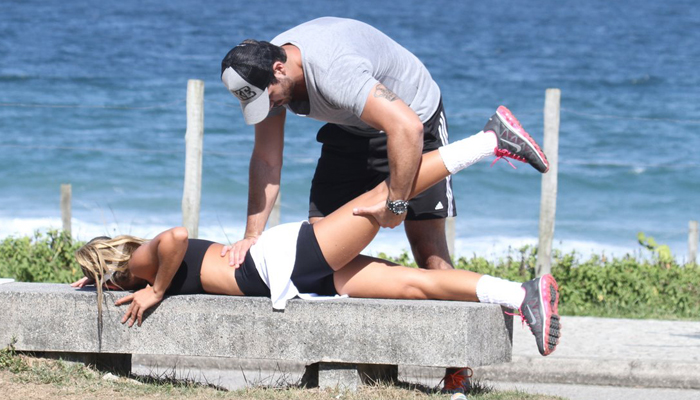 Ex-BBB Rodrigão faz massagem na namorada Adriana na praia