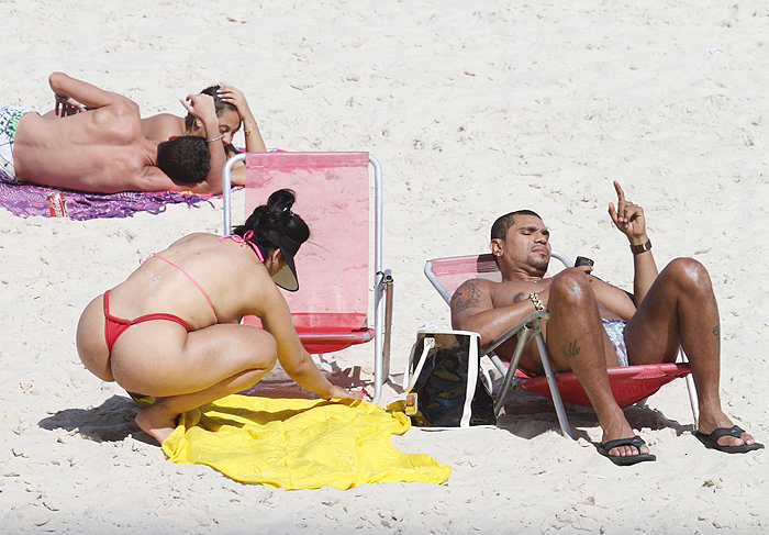  MC Naldo passa bronzeador em Mulher Moranguinho na praia